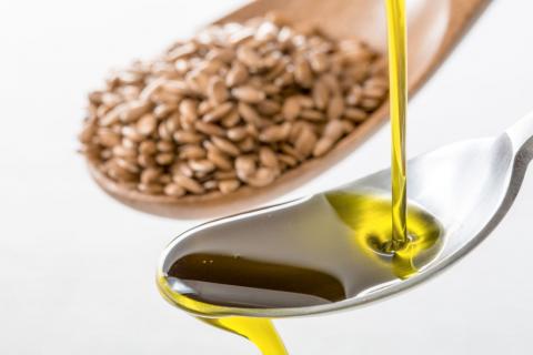 Flaxseed oil being poured on a spoon.