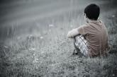 Boy sitting alone in grass