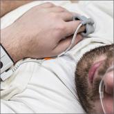 Man lying down with device on finger