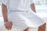 Man sitting on exam table in gown