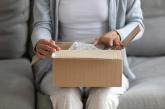 Woman opening box on couch