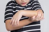 Child holding their elbow