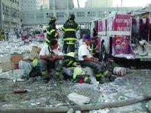 New York City firefighters take a much-needed break during emergency response efforts following the 9/11 attacks.