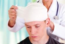 A boy is having his head wrapped following a concussioin.