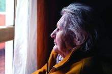 depression in the elderly: An elderly woman gazes out the window.
