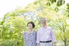 An old couple smiling while outdoors