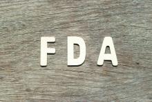 FDA written in white letters on a wood background.