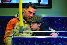 Foster care father and son embrace on bus