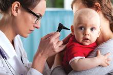 A doctor examines a baby's ear