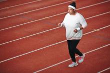 Black woman jogging on running track.