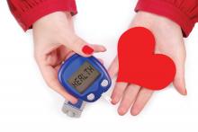 Hands hold a glucose monitor and a red heart
