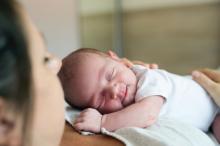 A newborn baby lies on mother's chest.