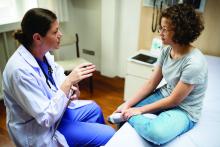 Doctor talking with teen girl.