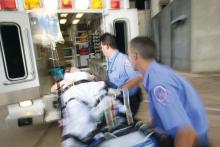 Paramedics wheel a patient into an ambulance.