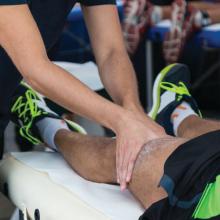 A trainer massages an athlete's leg