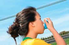 Girl using an asthma inhaler on a sports field