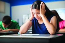 stressed teenage girl taking test in school