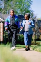 An older couple walks along a path.