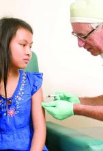 Young girl receiving a vaccination from her health care provider.