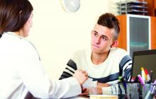 Female doctor questioning teen patient at office