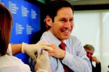 CDC Director Dr. Tom Frieden receives a flu shot at the press conference.