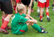 Boy sitting on soccer field