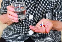 A woman prepares to take a handful of pills.