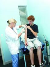 Teen male is shown receiving a vaccination.