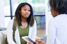 African American teenage girl talks with high school guidance counselor,