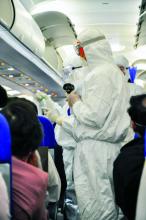 Medics in white hazmat protective suits checking and scanning passengers in a plane for epidemic virus symptoms.