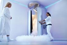 A woman approaches a cryotherapy chamber
