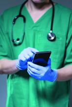 Close-up of doctor using phone while wearing gloves