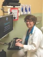 Family physician Dr. Carla L. Kakutani of Winters, Calif. sits at her computer.