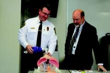 Dr. Eric Collins (right) watches an EMT during a training session in New Canaan, Ct., that included instruction on naloxone administration.