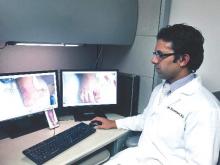 Dr. Raja Sivamani of the University of California, Davis, scans patient images at his desk. His research includes teledermatology with a focus on integration of mobile phone photography and cloud-based communications. 