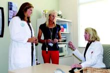 Dr. Jeanne A. Conry (seated) talks with her care team: Kim Marjama (L), a nurse practitioner, and Judith Erickson, the unit manager.