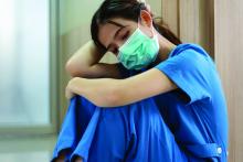 exhausted nurse sitting on floor in hospital