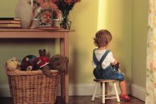 A child sits in the corner in a timeout