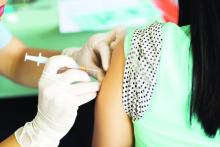 Womans arm, vaccination needle